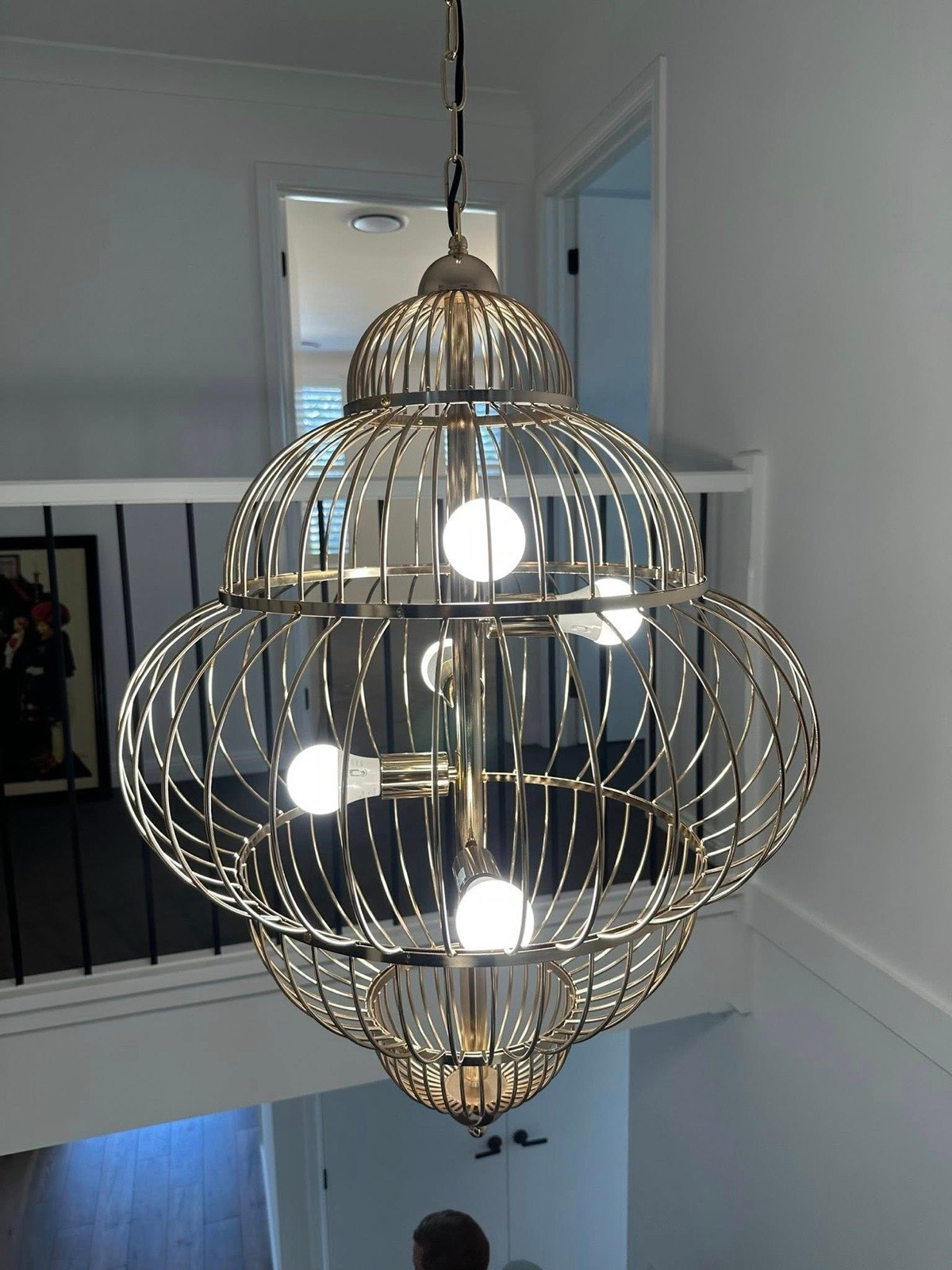 Ornate cage-style pendant light hanging in a stairwell