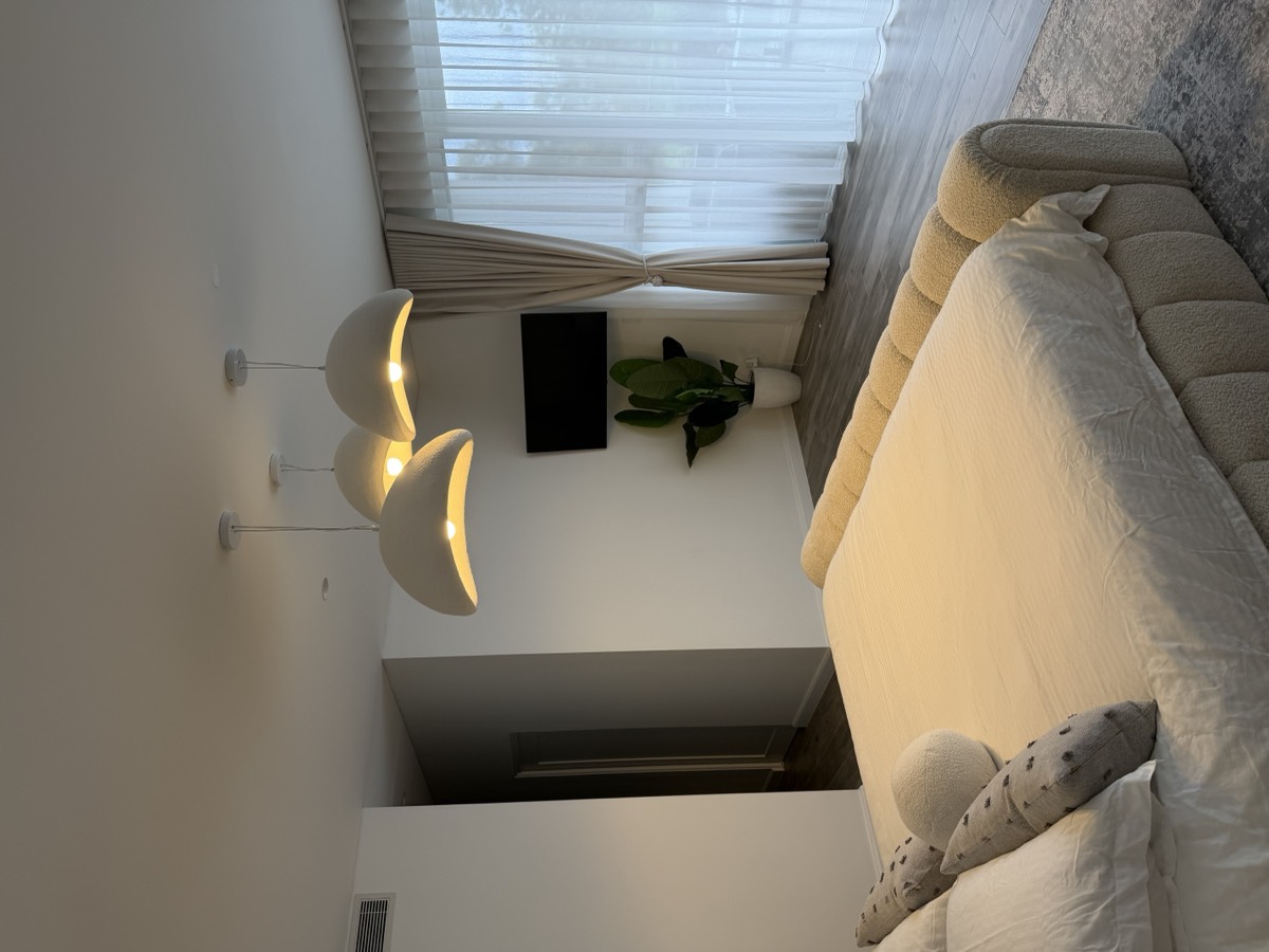 Sculptural pendant lights over a main bedroom