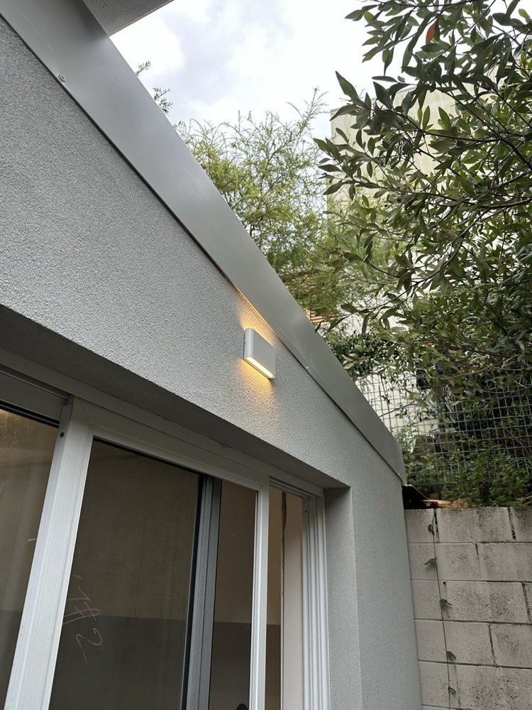 Outdoor wall light on a rendered wall