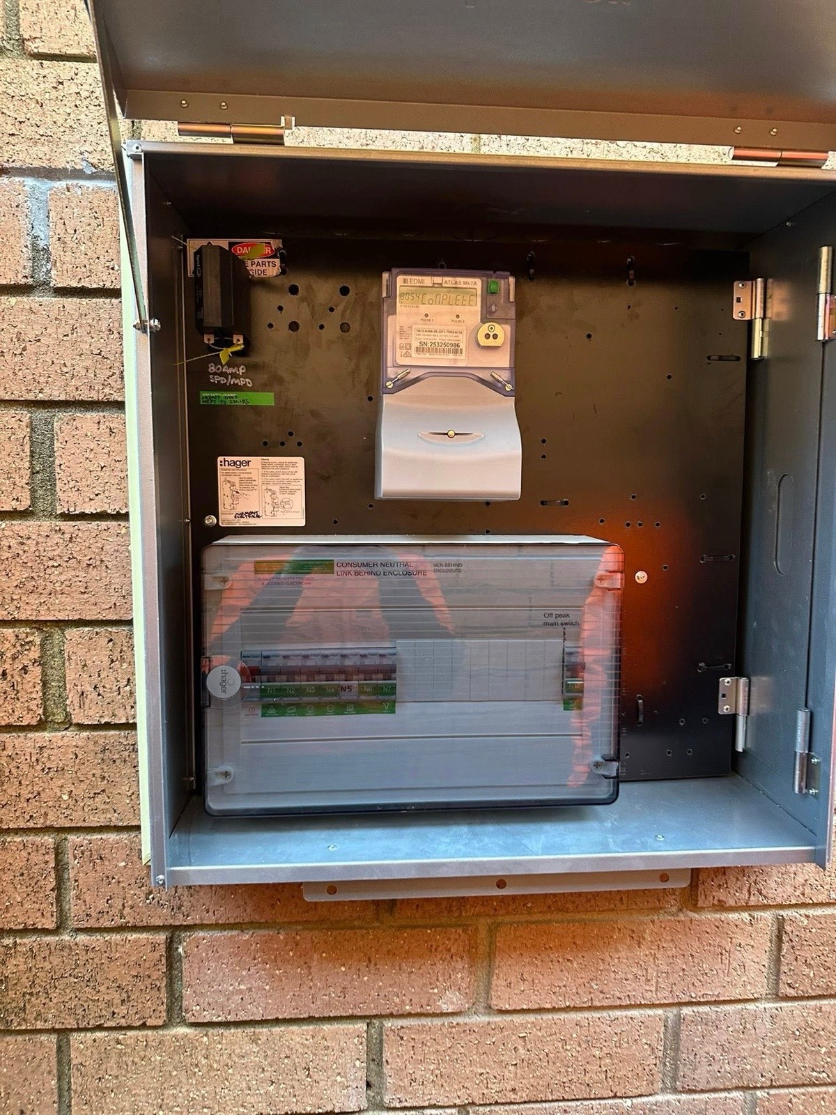 Open switchboard meter box mounted on a brick wall