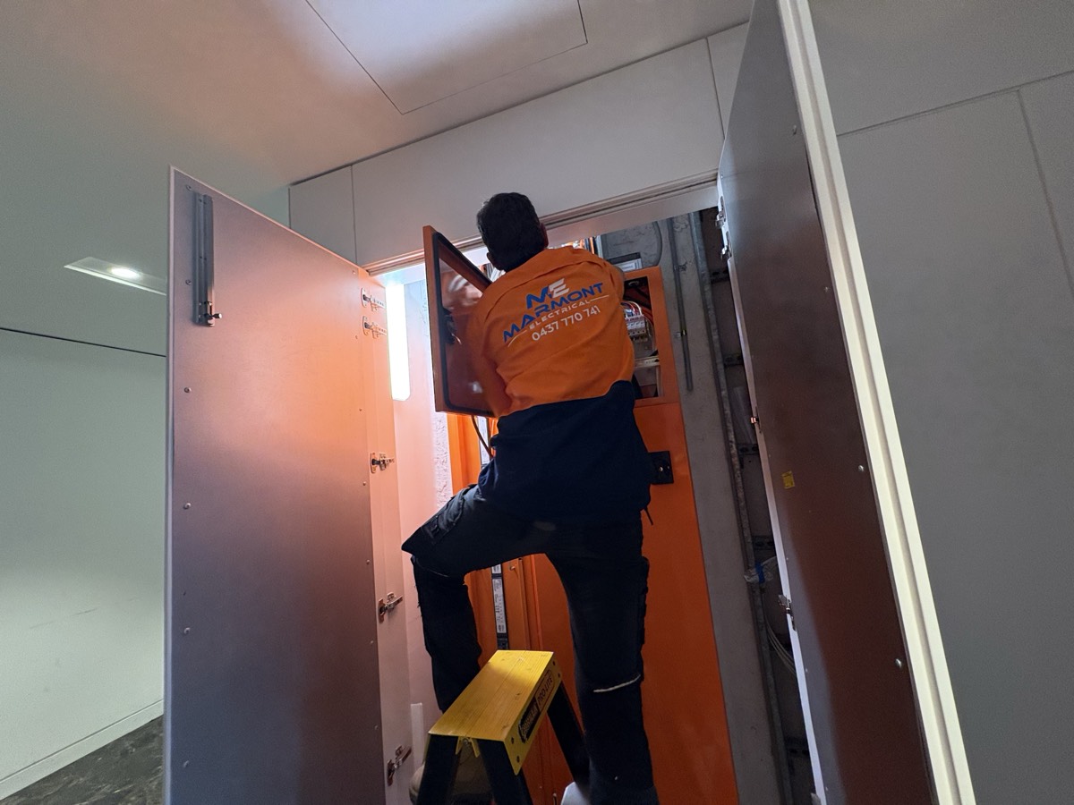 Marmont Electrical electrician working on a commercial distribution board from a ladder